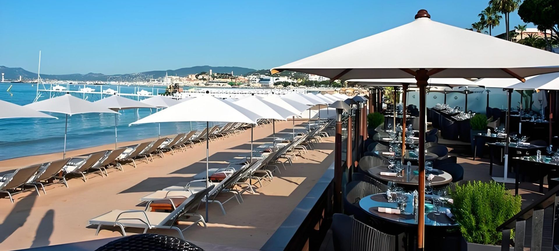 Plage privée de l'Hôtel Martinez in The Unbound Collection by Hyatt avec des parasols bleus et des chaises longues面对着地中海