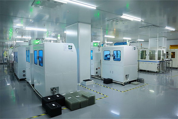 Cleanroom environment for LCD manufacturing with technicians in protective gear monitoring automated production equipment